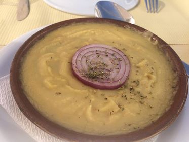 サントリーニ発祥の伝統料理『ファヴァ』。キマメ（豆）やニンジン、タマネギを煮てピュレにしたもの。地味に見えるけど美味しい！ のっている生タマネギが良くあいます。パンに乗せて食べるのがオススメ