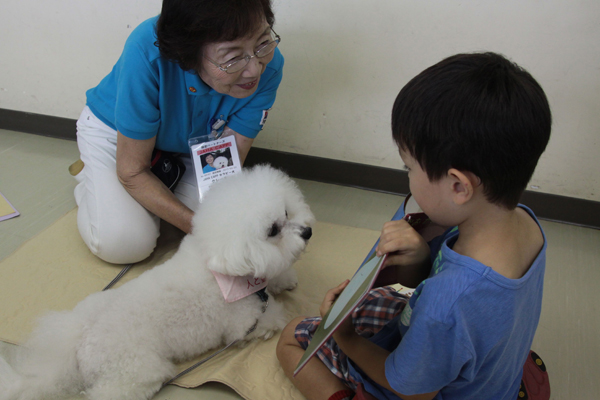 ちゃんと犬に絵本を見せながら読む子（ｃ）大塚敦子