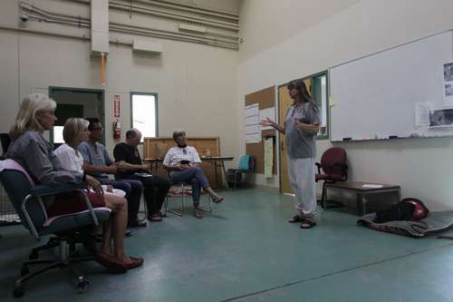 犬を外に連れ出すボランティアにレクチャーする受刑者 ©大塚敦子