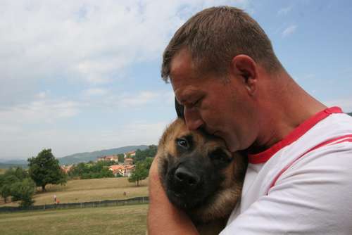 カンボジアに旅立つ犬を抱きしめるトレーナー（ｃ）大塚敦子